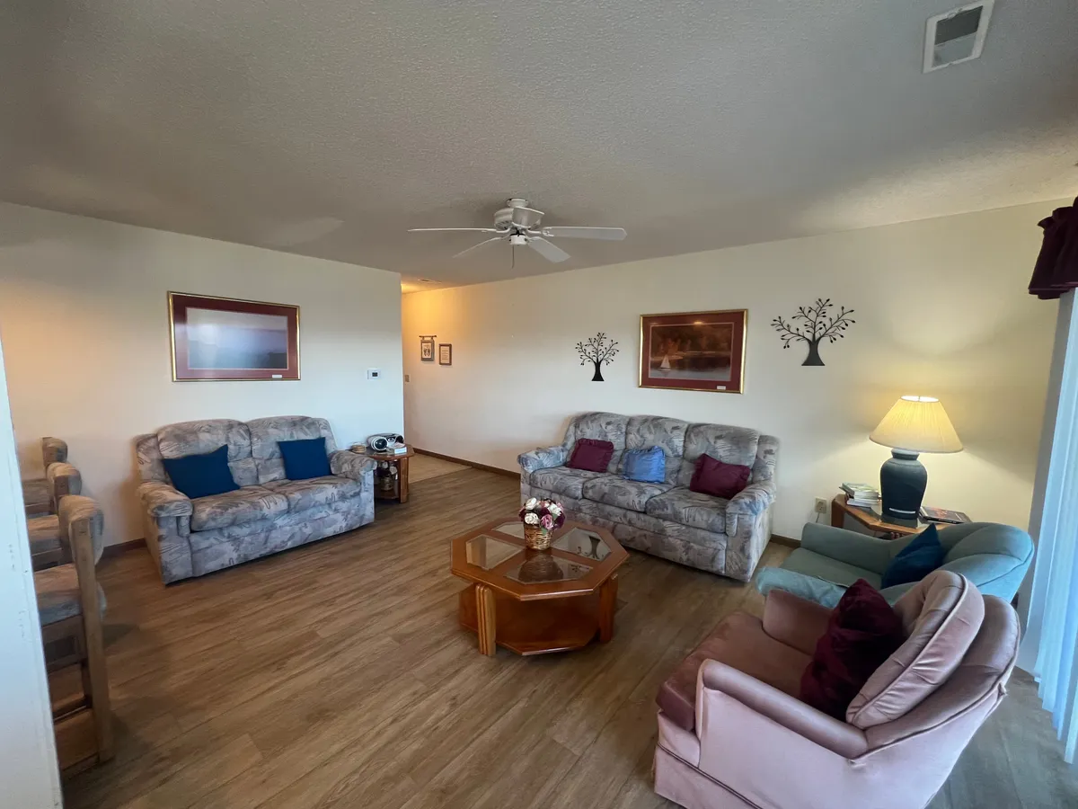 A warmly-lit living room with vintage-inspired sofas, a coffee table, classic lamp, and nostalgic wall art. The space is inviting, perfect for unwinding after a day of exploring Branson or sharing a quiet moment over coffee.